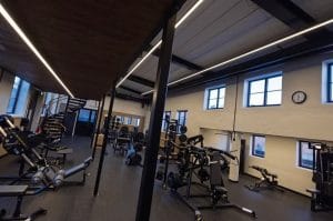 Armaturen Flow, pendlad med upp- och nedljus lyser upp gymmet i den gamla hästskofabriken, som nu blir konferensanläggning med idrottshall och gym.